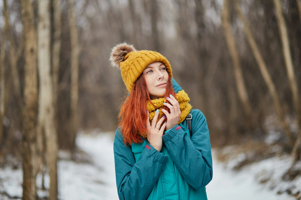 Woman in a knit cap standing in the snow